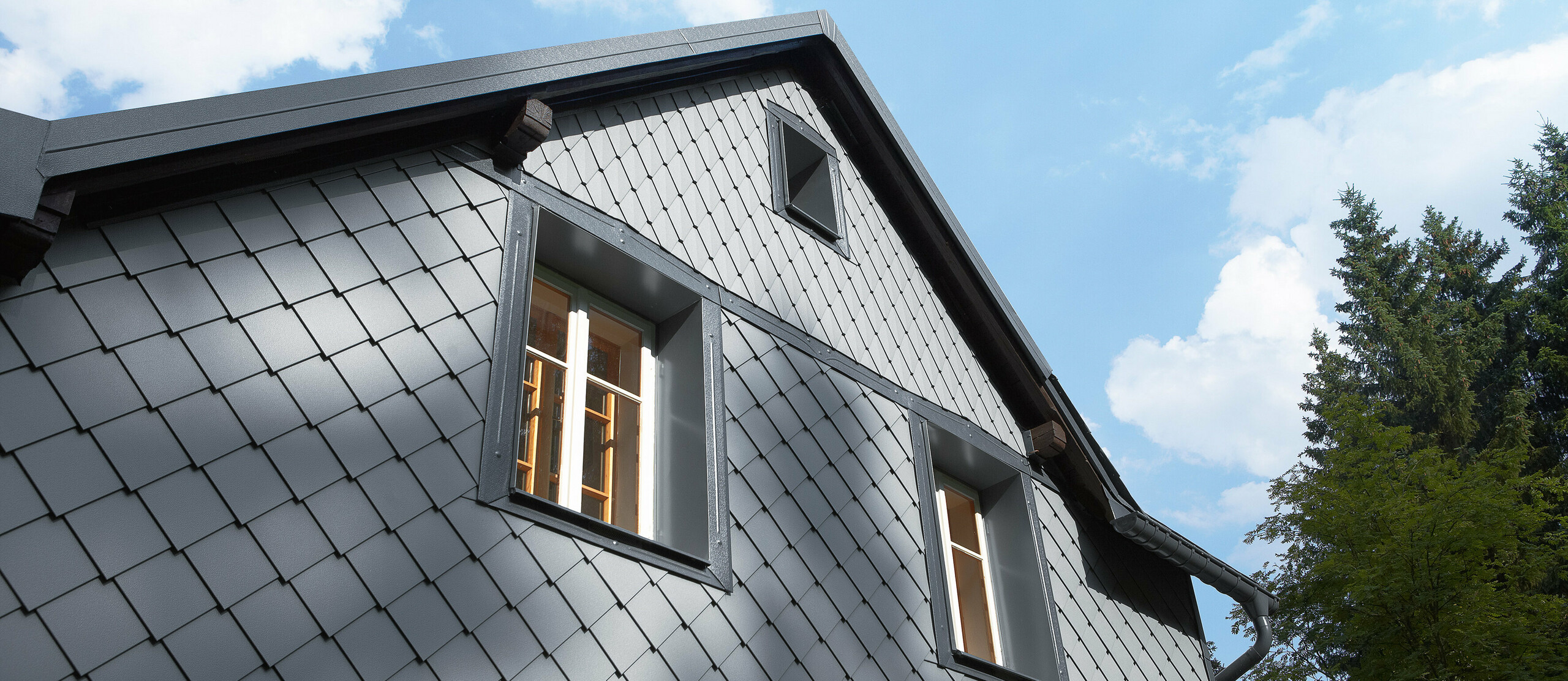 Wetterseite verkleidet mit der Wandraute 20 × 20 und der kleinen Raute an der Fassade von PREFA