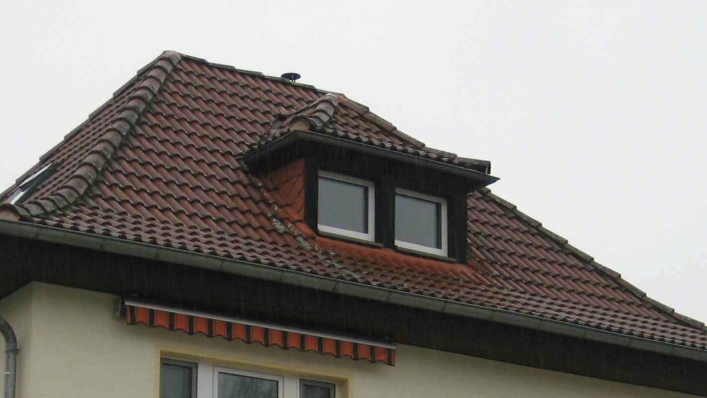 Valbová střecha s pultovým vikýřem před sanací za použití PREFA falcovaných střešních šindelů