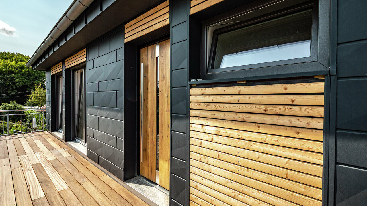 Dřevo na fasádě a terase domu doplněno o hliníkové fasádní panely