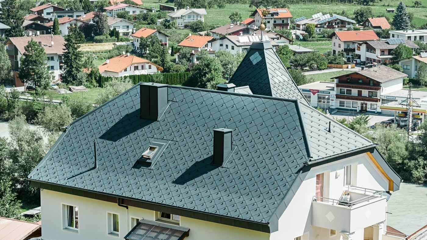 Polovalbová střecha s věží, pokrytá hliníkovou střešní šablonou 44 × 44 antracitové barvy.