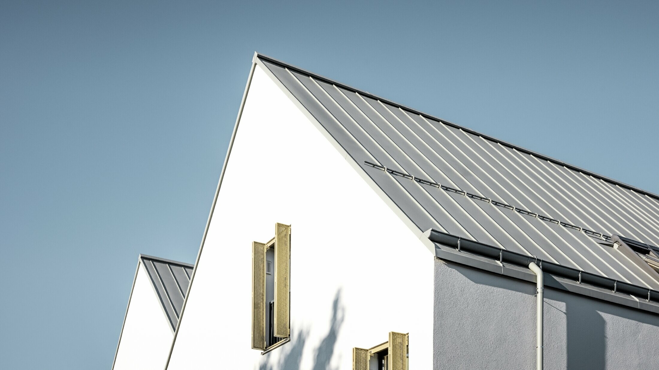 Sedlová střecha bez převislé střechy, pokrytá PREFALZem v provedení P.10 zinkově šedá s nástřešním žlabem PREFA