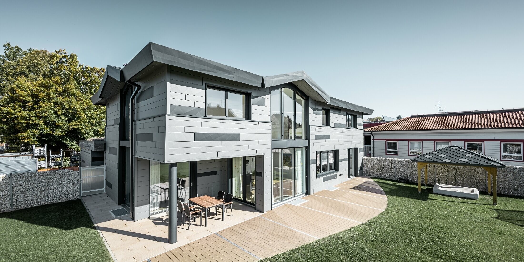 Moderní rodinný dům v Türkheimu se zajímavou fasádou z fasádních lamel FX.12 v barvách P.10 světle šedé a antracitové.