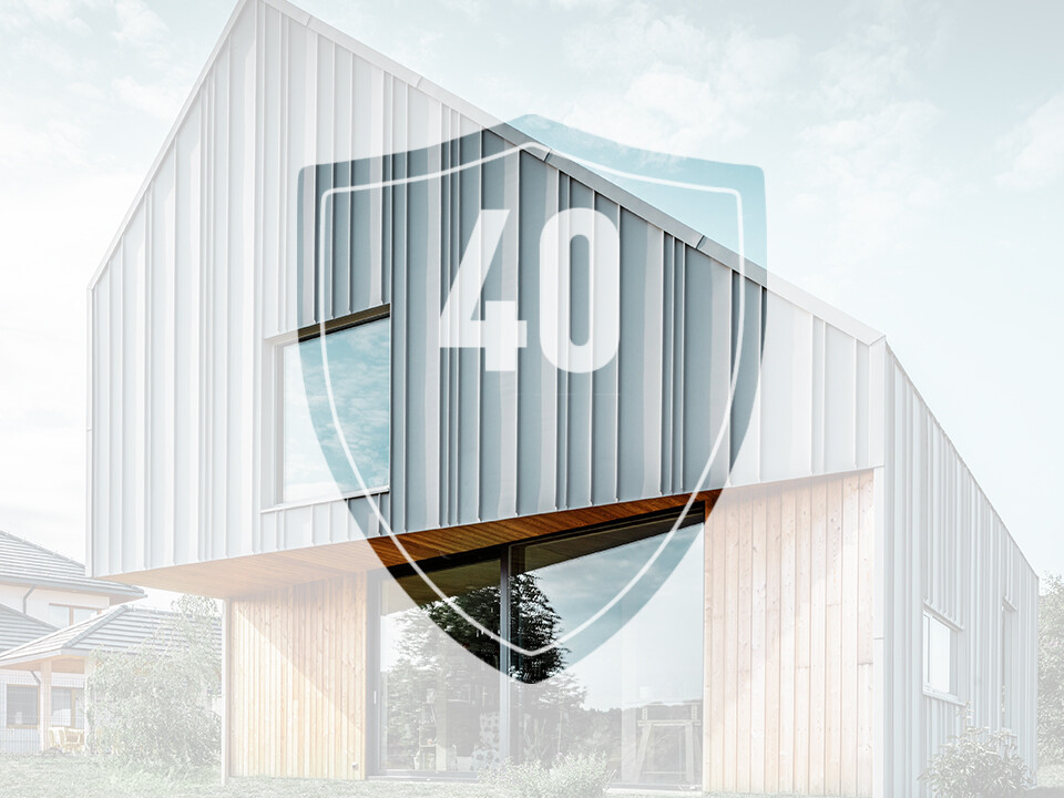 Na obrázku je před moderním rodinným domem umístěna cedule s číslem „40“, která má představovat délku záruky na hliníkové výrobky PREFA.