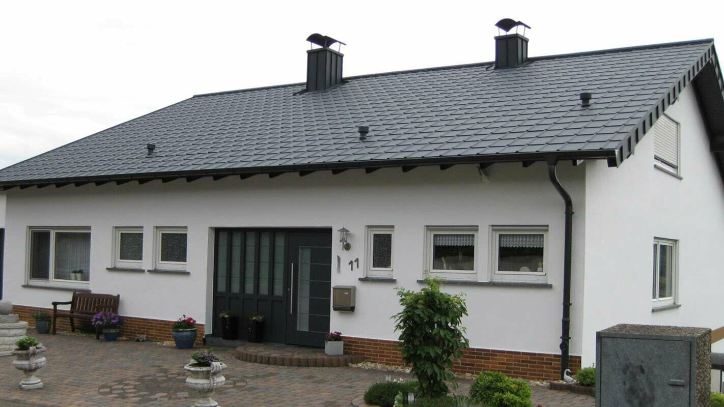 Rodinný dům s jednoduchou sedlovou střechou po její sanaci za použití PREFA falcovaných střešních tašek 