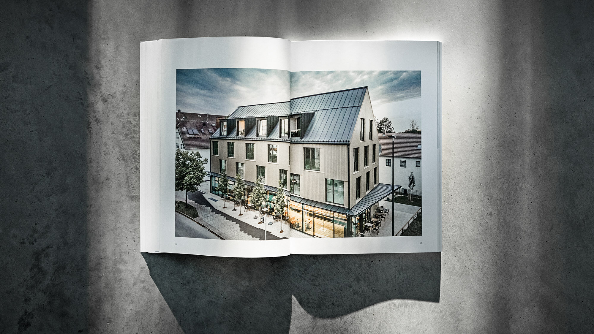 Otevřená PREFARENZEN kniha 2024 s článkem o projektu Walters Restaurant od dreiplus architects na šedém pozadí.