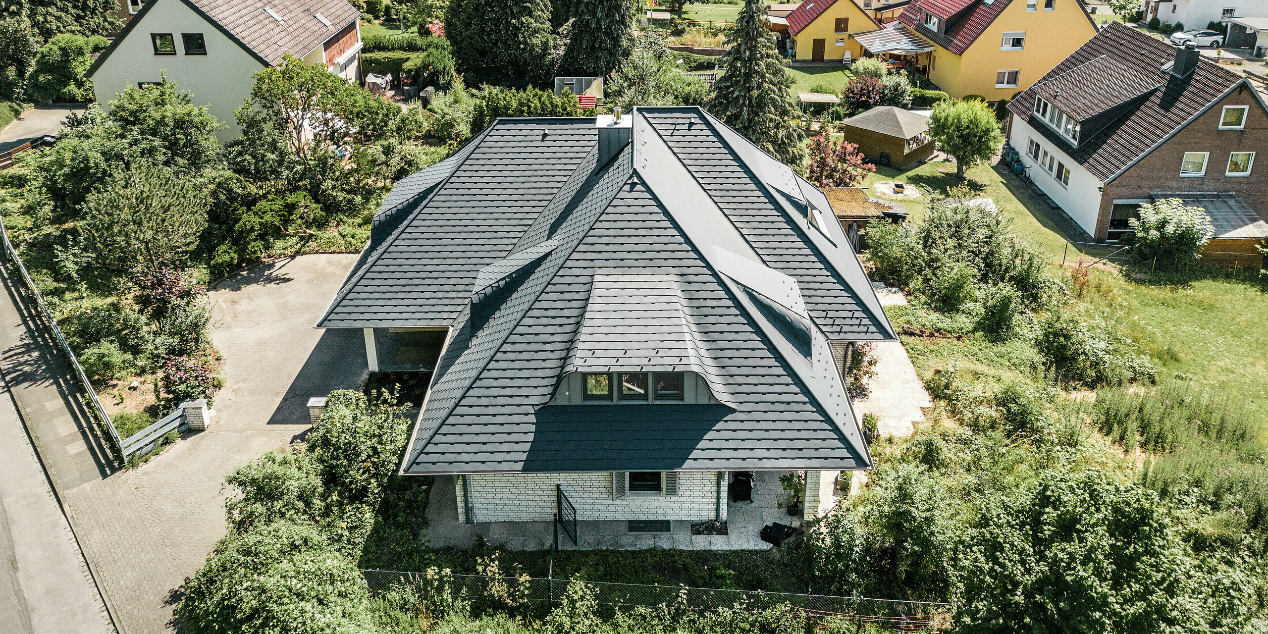 Pohled z ptačí perspektivy na dům s falcovaným šindelem PREFA