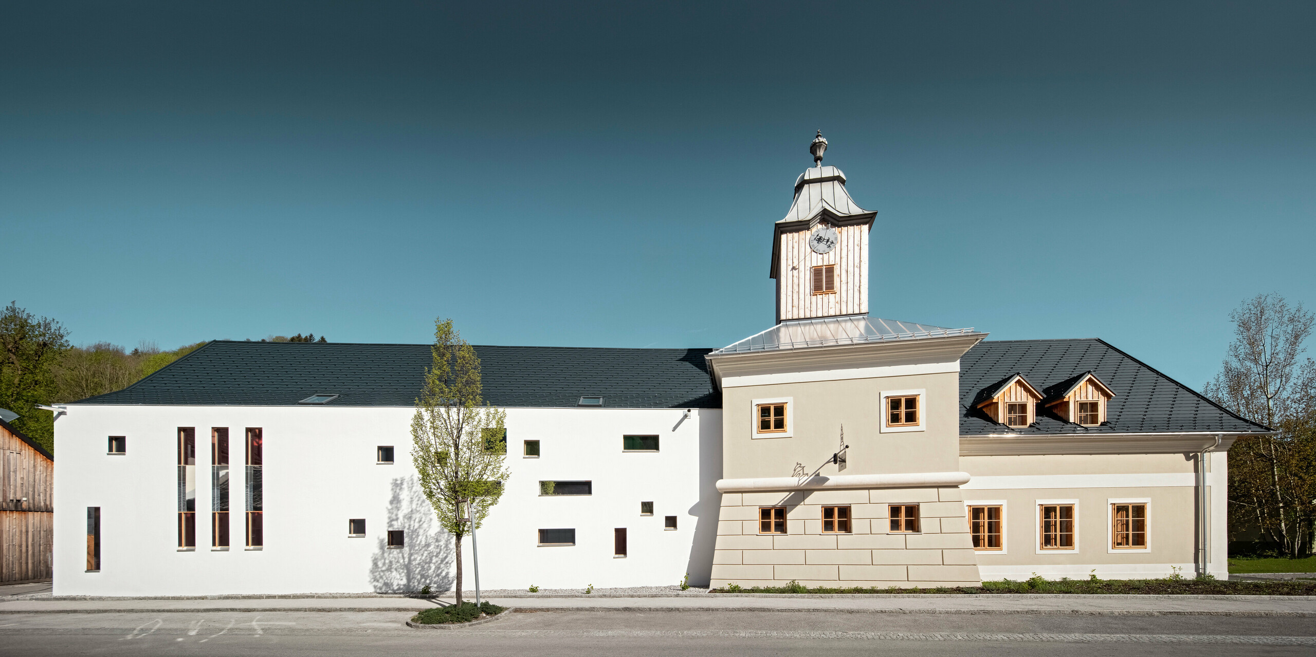 Pohled na hotel Zvonice v Marktl Lilienfeldu se střechou pokrytou falcovanými šindeli PREFA v barvě P.10 antraictové.