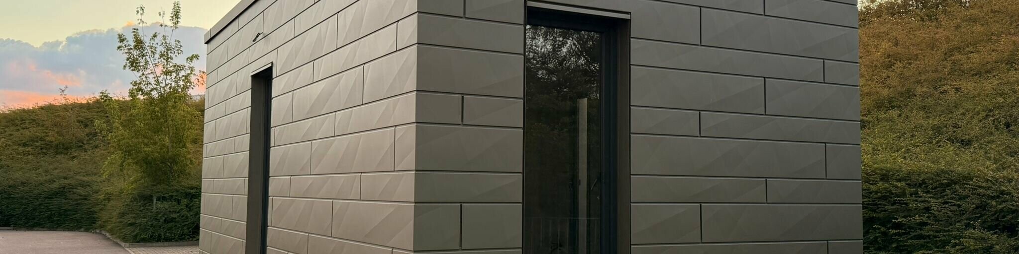 Tiny house - zadní pohled na objekt při západu slunce. Siding.X vytváří na fasádě hru světla a stínu