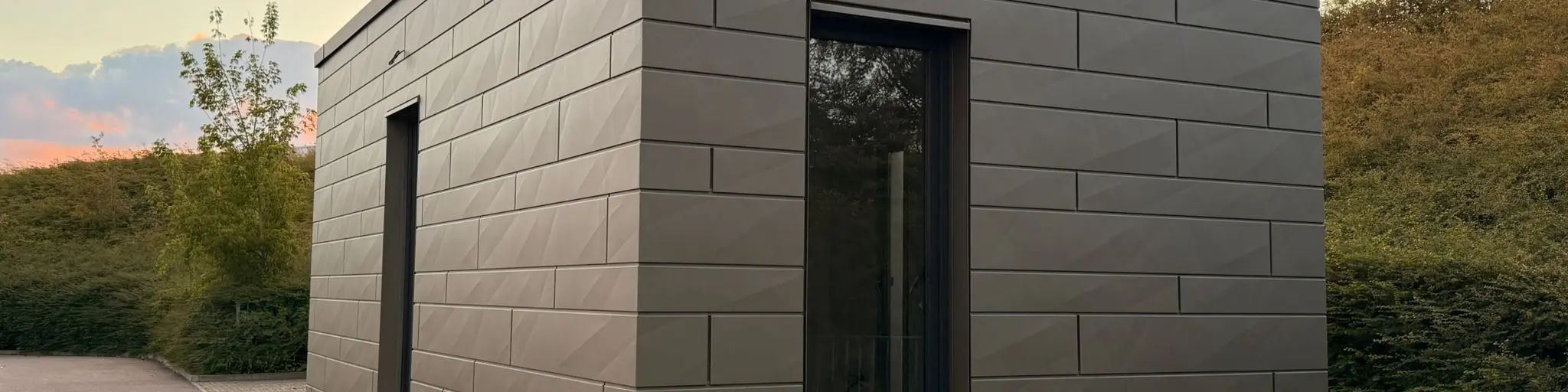 Tiny house - zadní pohled na objekt při západu slunce. Siding.X vytváří na fasádě hru světla a stínu