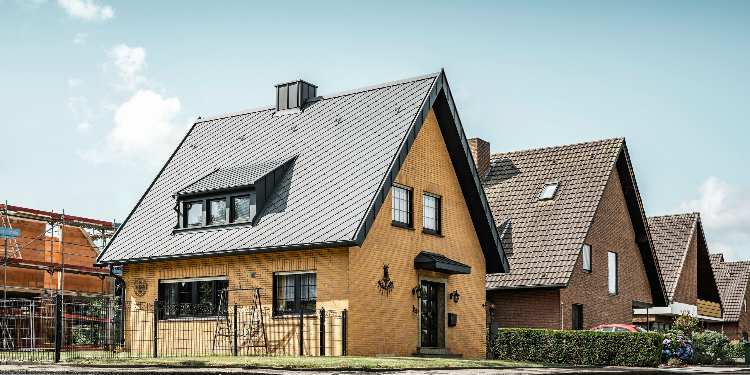 Rodinný dům s materiály PREFA vyčnívá z řady domků moderním vzhledem a střešní krytinou 