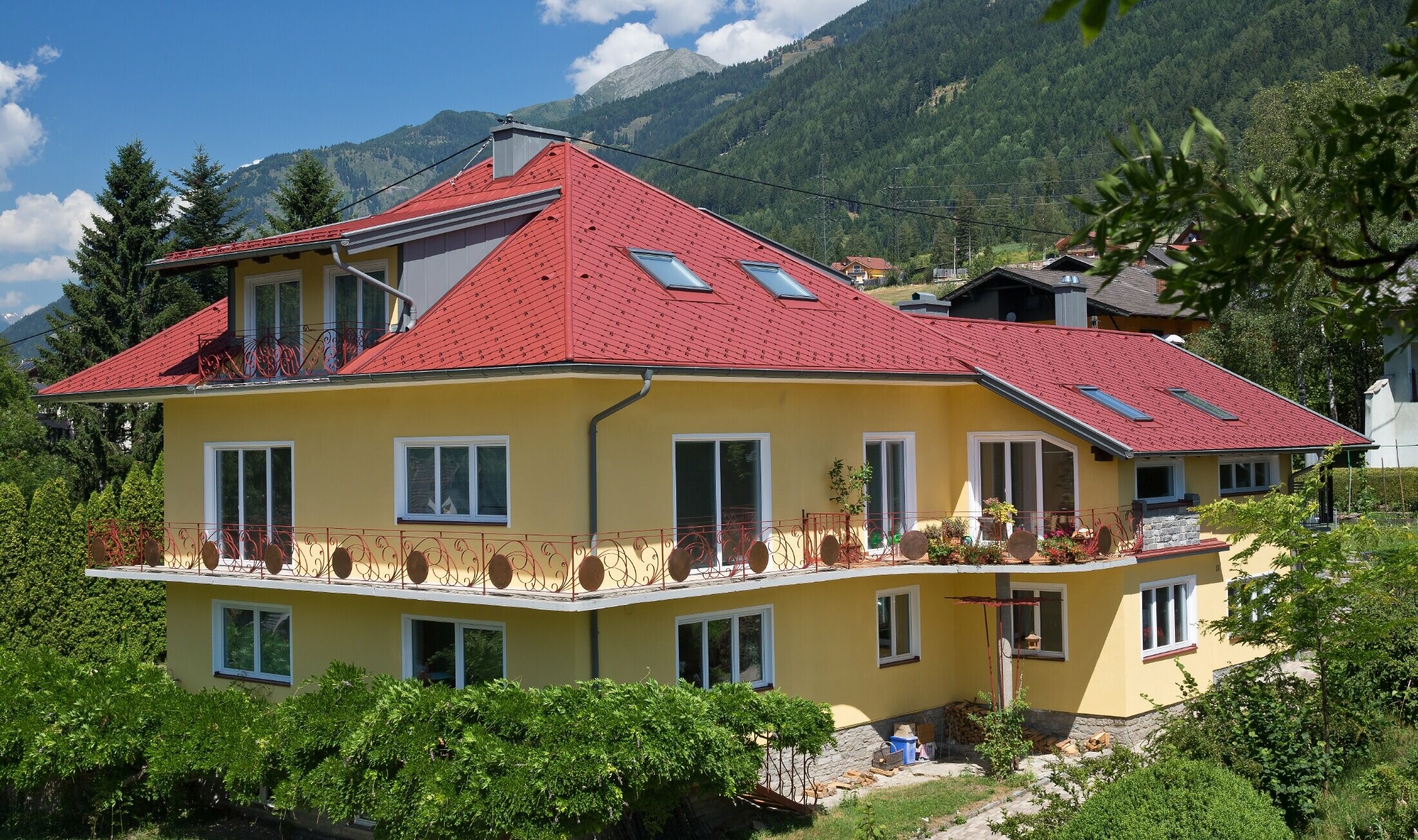 Klasický rodinný dům s valbovou střechou pokrytou falcovanými šablonami 29 × 29 v barvě P.10 tmavě červené