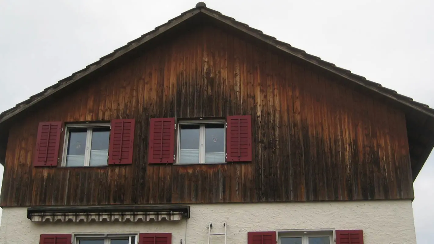Fasáda domu se zvětralým dřevem před sanací za použití PREFA Sidings