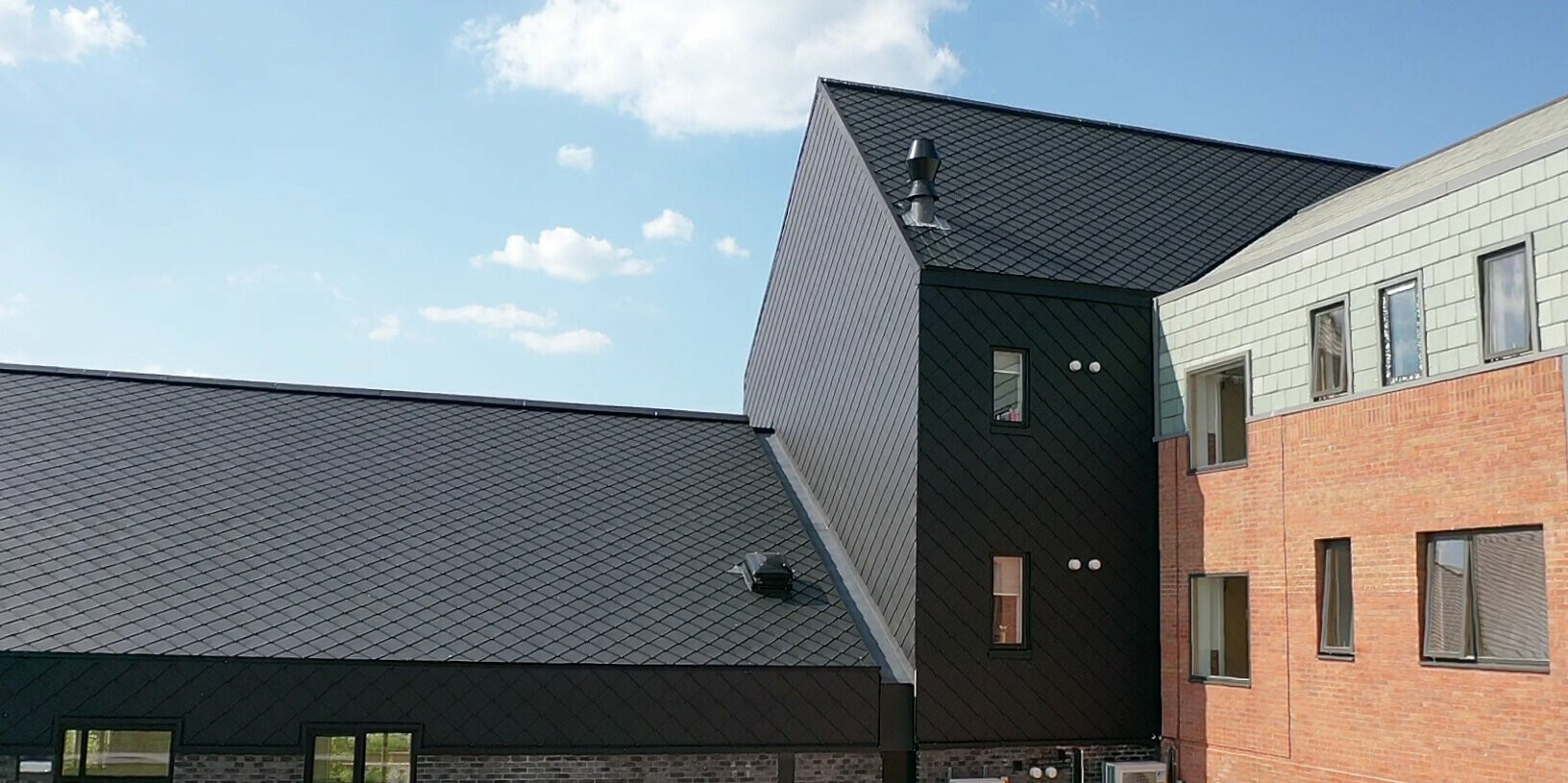 Černé hliníkové šablony 29 x 29 od PREFA na střeše i fasádě pečovatelského zařízení v Prestonu.