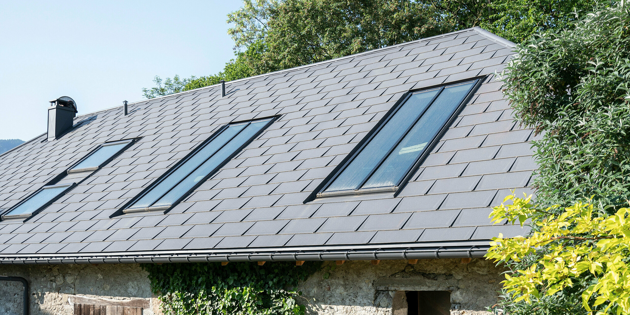 PREFA střešní panel R.16 v barvě P.10 tmavě šedá na střeše zemědělské usedlosti v Héry-sur-Alby (Francie)