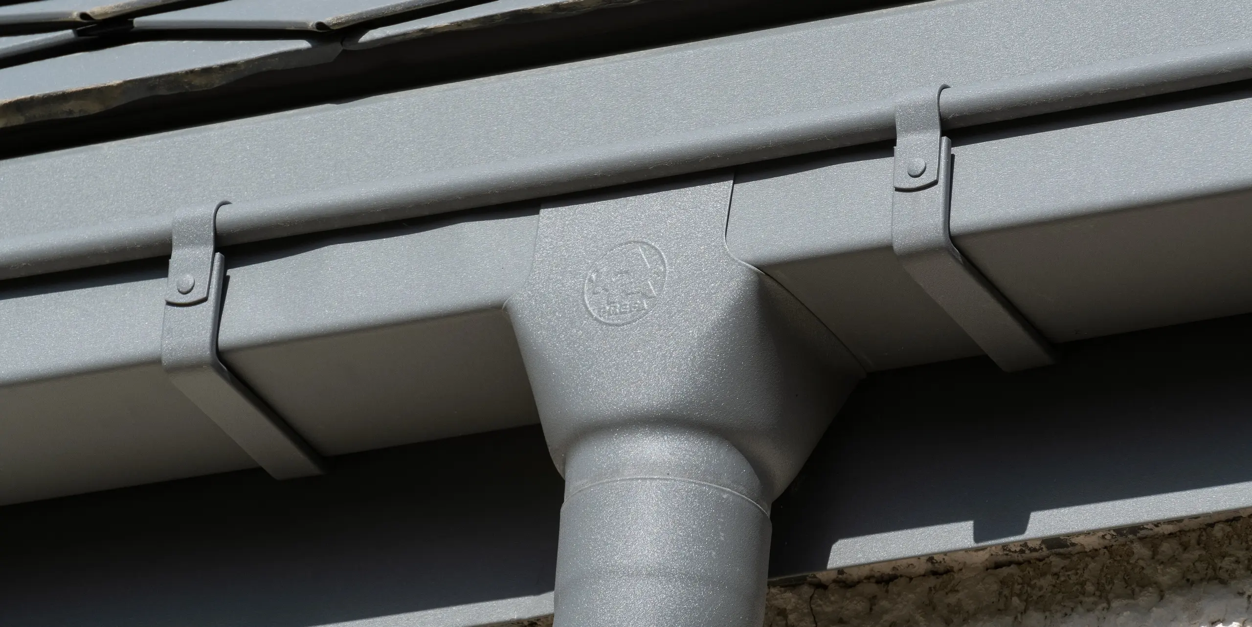 Detail odvodňovacího systému (hranatého žlabu a kruhového svodu) od PREFA