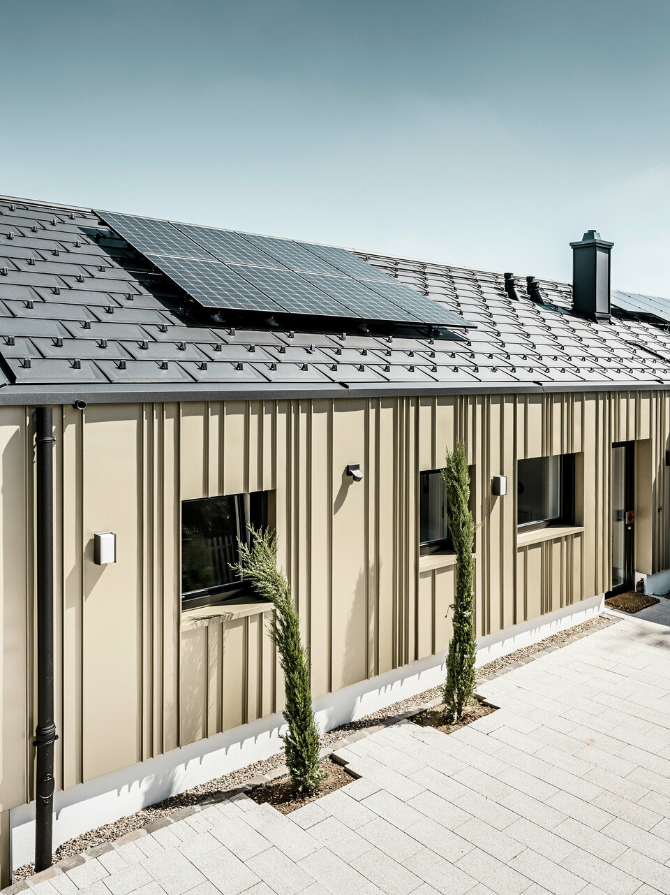 Novostavba v Bad Münstereifel byla pokryta střešním panelem PREFA R.16 v barvě P.10 antracitové. Na střeše je fotovoltaický systém. Fasáda je opláštěna hliníkovým plechem Falzonal ve světlém bronzu.