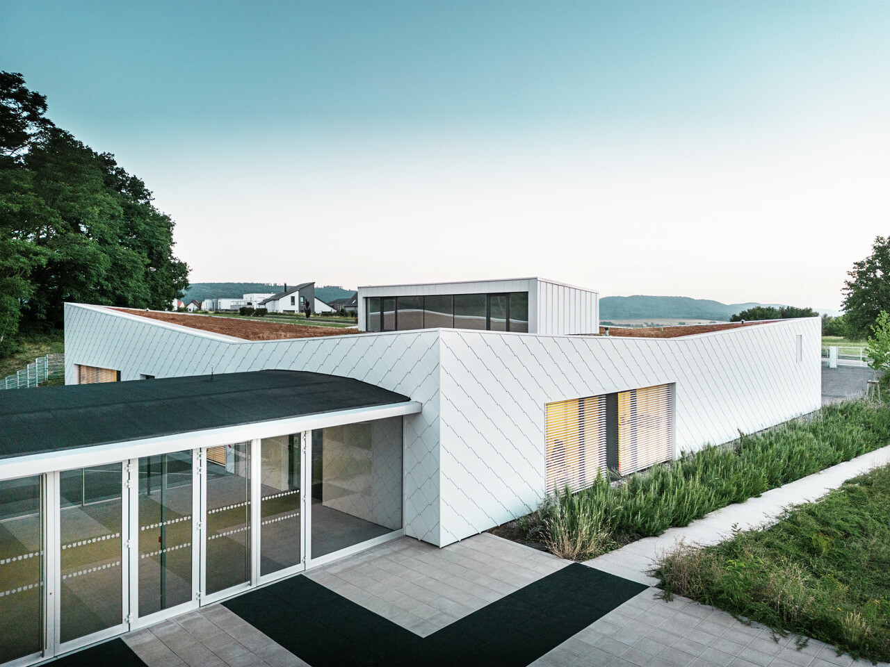 Nově postavená budova školky a školy v Otterswilleru s fasádní šablonou PREFA 44 × 44 v barvě P.10 prefa bílé.