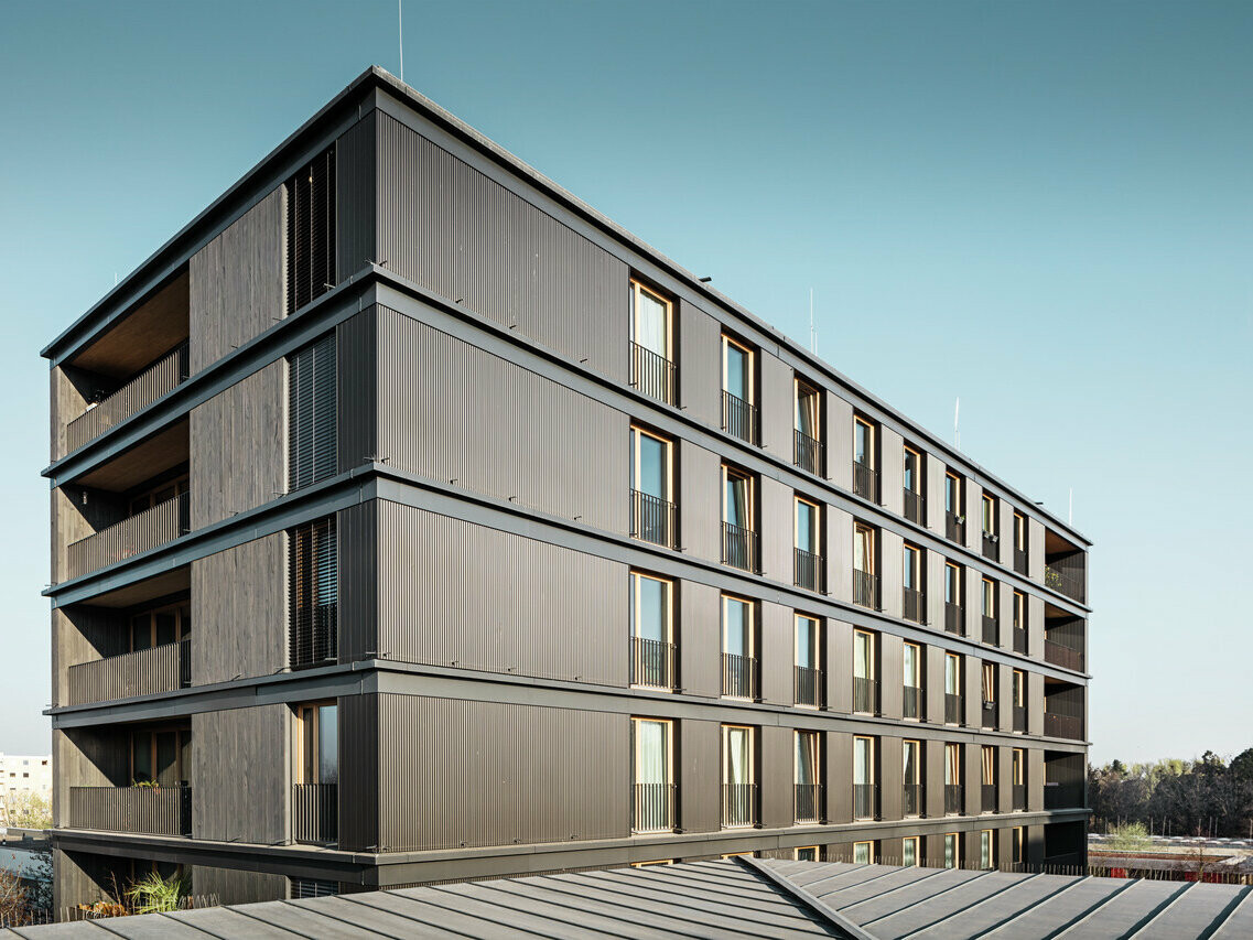 Obrázek multifunkční budovy pokryté vlnitou hliníkovou fasádou Profilwelle od PREFA ve Freiburgu v Německu.