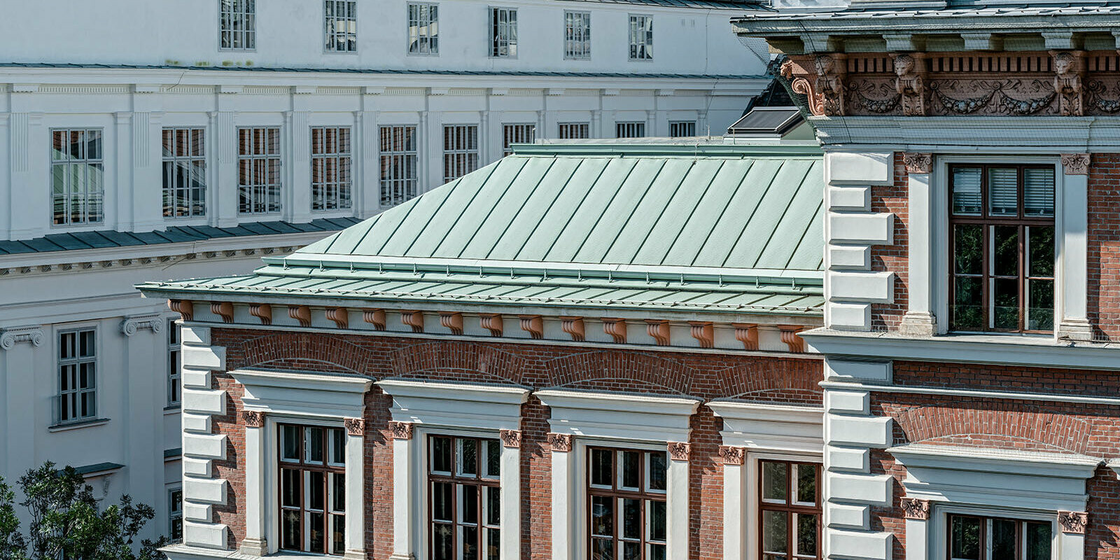 Detailní pohled na střešní systém PREFALZ od PREFA v barvě na přání - opálově zelené na budově evangelické základní školy na Karlsplatz ve Vídni.