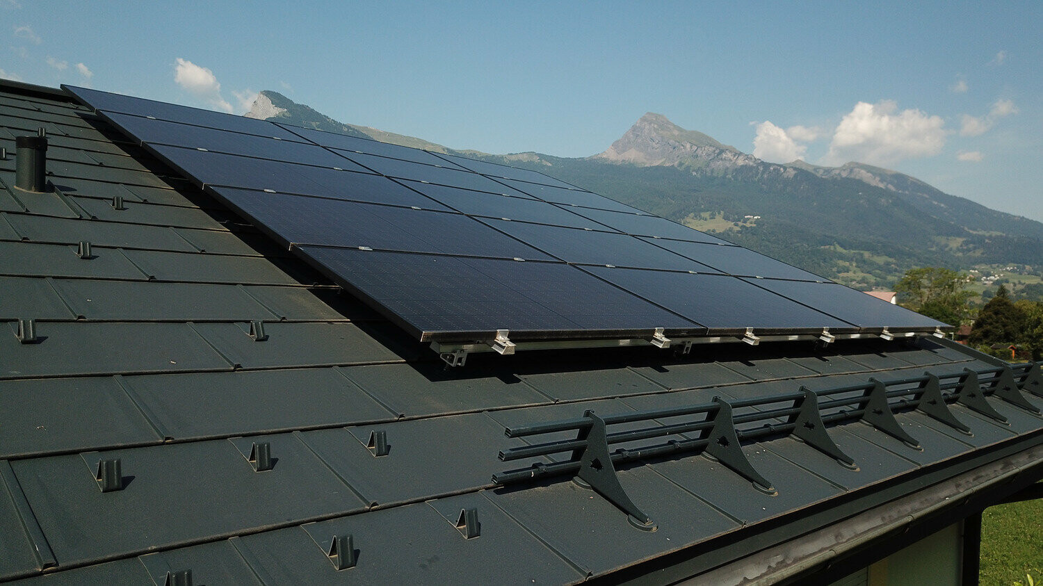 Fotovoltaický systém na střeše pokryté střešním panelem PREFA R.16 v antracitové barvě.