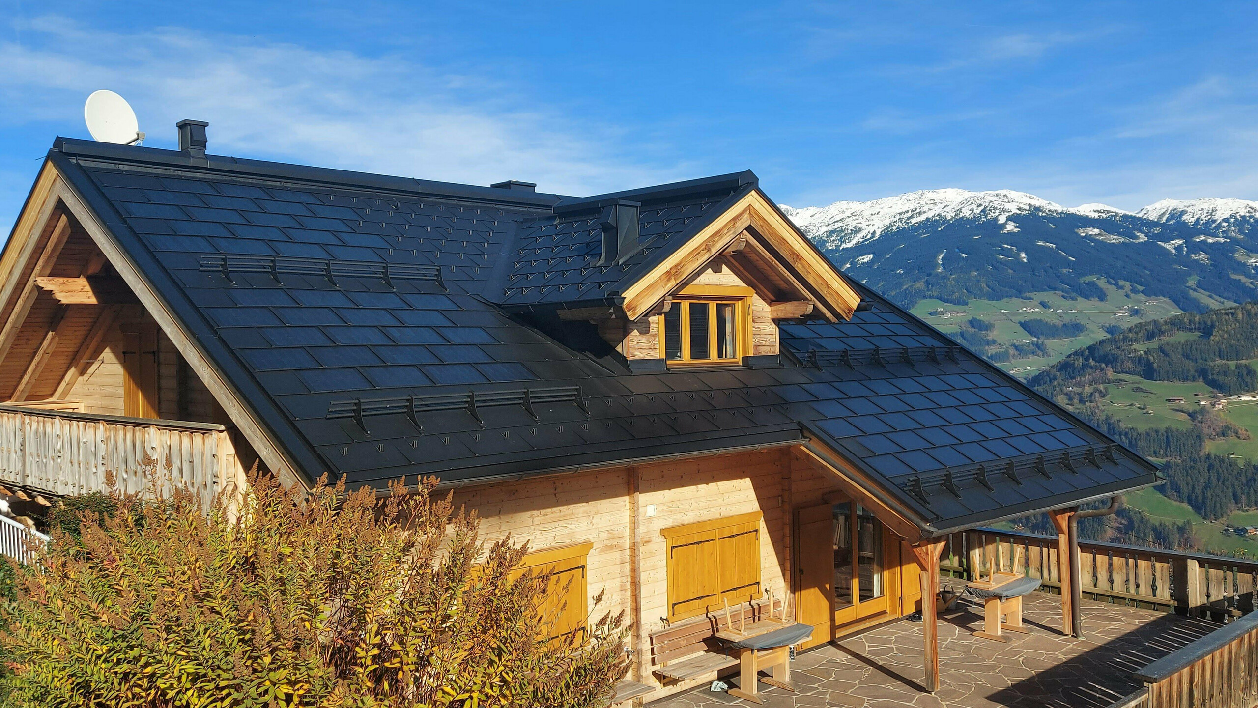 Rekonstrukce rodinného domu v Hippachu (Tyrolsko) s malým integrovaným solárním panelem SDP v barvě P.10 černé v kombinaci se střešním panelem PREFA R.16