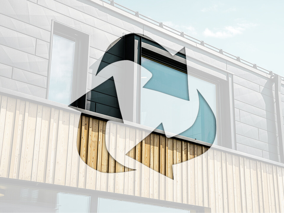 Fotografie znázorňuje symbol recyklace před domem s hliníkovými fasádními prvky PREFA a dřevěnými panely.
