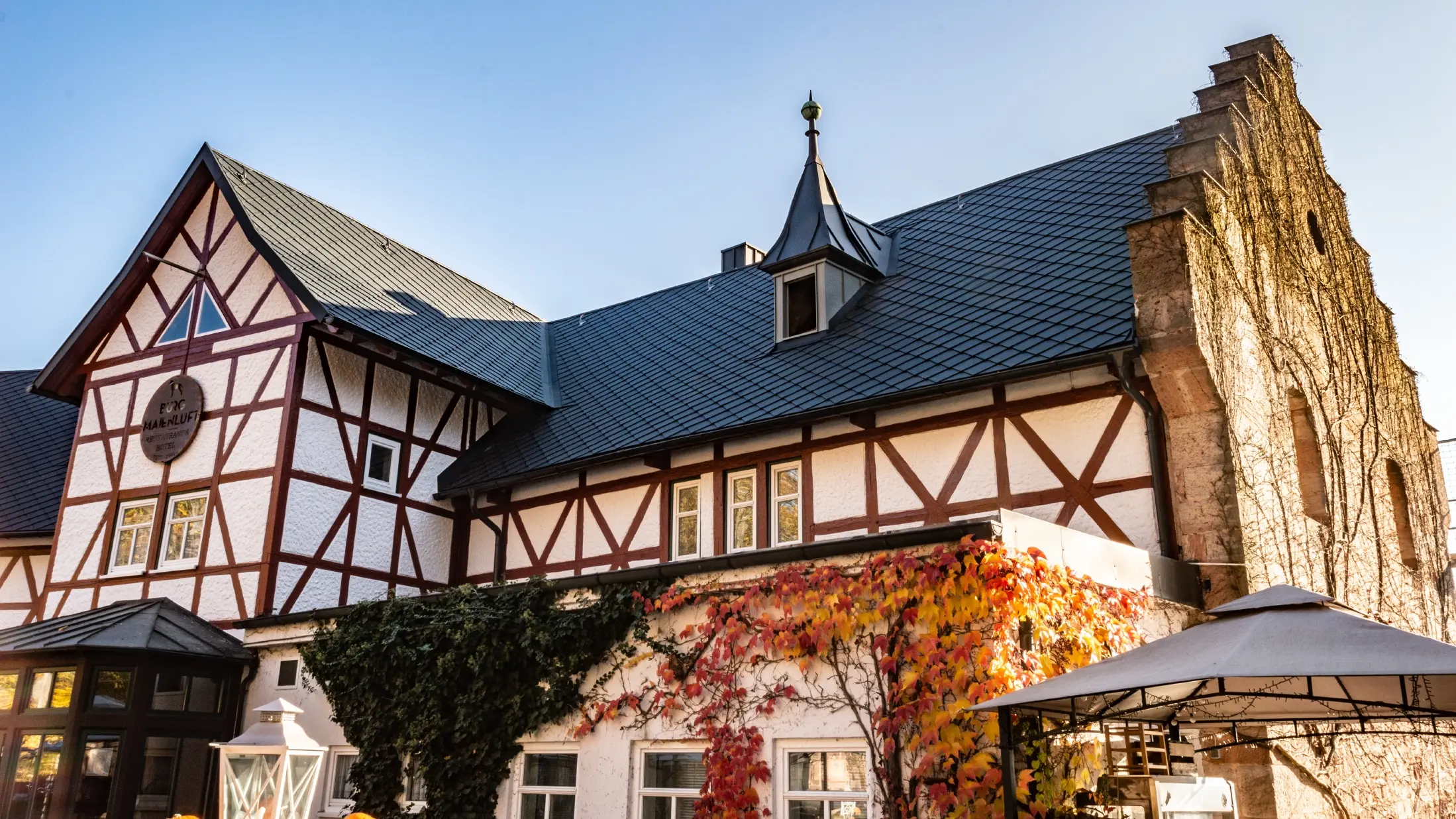 Hotel Maienluft po rekonstrukci střechy, kterou chrání falcovaná šablona 29 × 29 v barvě P.10 antracitové. Objekt má hrázděnou fasádu.