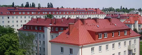 Snímek souboru bytových domů Hugo-Breitner-Hof ve Vídni. Střechy byly pokryty PREFA falcovanými střešními šindeli v barvě cihlově červené