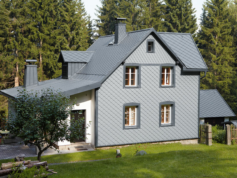 Rodinný dům v lese s PREFA hliníkovou fasádou ve světle šedé odolnou vůči počasí.