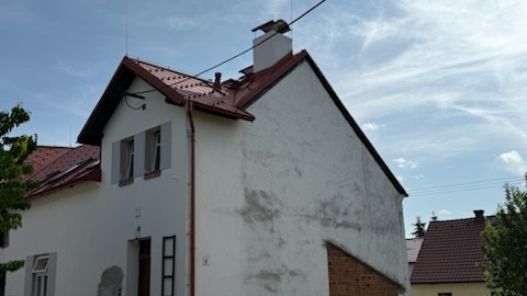 Boční pohled na budovu s novou střešní krytinou od PREFA se 40letou zárukou na barvu i materiál. 