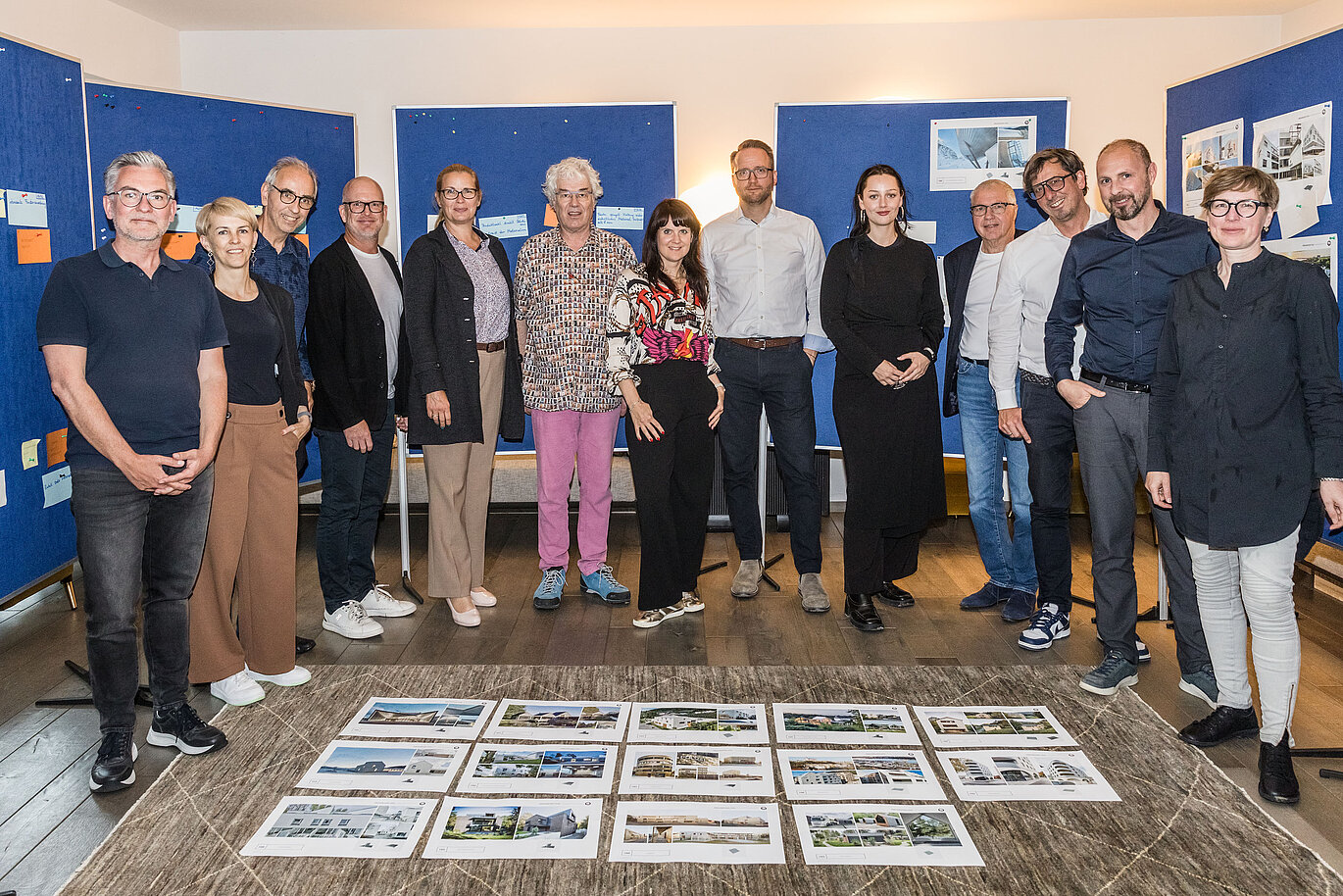 Společná fotografie poroty PREFARENZEN 2026 po úspěšném výběrovém řízení ve vinařském sídle v regionu Seewinkel v Burgenlandu: Interdisciplinární skupina expertů ve složení Dirk Lorenz (Leinert Lorenz Architects), Veronika Roll (marketing, PREFA Rakousko), Wolfgang Croce (Croce & Wir, Graz), Jürgen Jungmair (manažer mezinárodního marketingu, PREFA), Judit Nemere (jednatelka PREFA Maďarsko), Matthias Finkentey (moderování), Bettina Almeida (komunikační management, PREFA), Christian Wirth (regionální manažer pro východ, PREFA Rakousko), Selina Wach (vedoucí diskurzu, Architektur Aktuell), Thomas Schlett (B3 Architects), Sven Disser (vedoucí rozvoje, Bauwerk), Falk Leinert (Leinert Lorenz Architects) a Juliane Croce (Croce & Wir, Graz) stojí před konečně vybranými architektonickými projekty pro Architektonickou knihu a kalendář PREFARENZEN 2026. Projekty odrážejí rozmanitost, udržitelnost a inovativní využití materiálů PREFA.