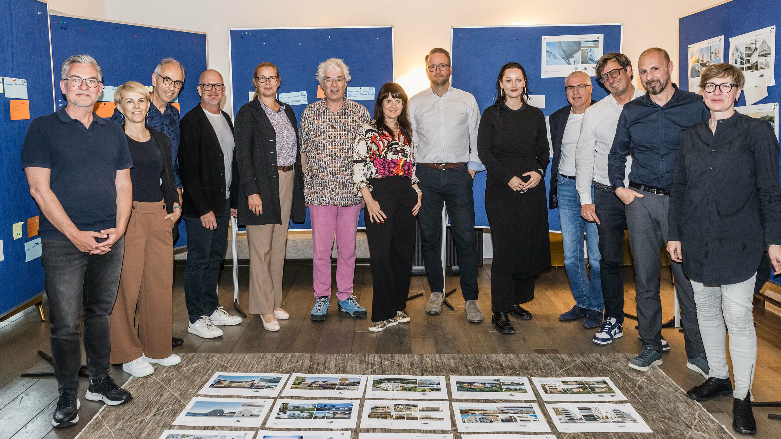 Společná fotografie poroty PREFARENZEN 2026 po úspěšném výběrovém řízení ve vinařském sídle v regionu Seewinkel v Burgenlandu: Interdisciplinární skupina expertů ve složení Dirk Lorenz (Leinert Lorenz Architects), Veronika Roll (marketing, PREFA Rakousko), Wolfgang Croce (Croce & Wir, Graz), Jürgen Jungmair (manažer mezinárodního marketingu, PREFA), Judit Nemere (jednatelka PREFA Maďarsko), Matthias Finkentey (moderování), Bettina Almeida (komunikační management, PREFA), Christian Wirth (regionální manažer pro východ, PREFA Rakousko), Selina Wach (vedoucí diskurzu, Architektur Aktuell), Thomas Schlett (B3 Architects), Sven Disser (vedoucí rozvoje, Bauwerk), Falk Leinert (Leinert Lorenz Architects) a Juliane Croce (Croce & Wir, Graz) stojí před konečně vybranými architektonickými projekty pro Architektonickou knihu a kalendář PREFARENZEN 2026. Projekty odrážejí rozmanitost, udržitelnost a inovativní využití materiálů PREFA.