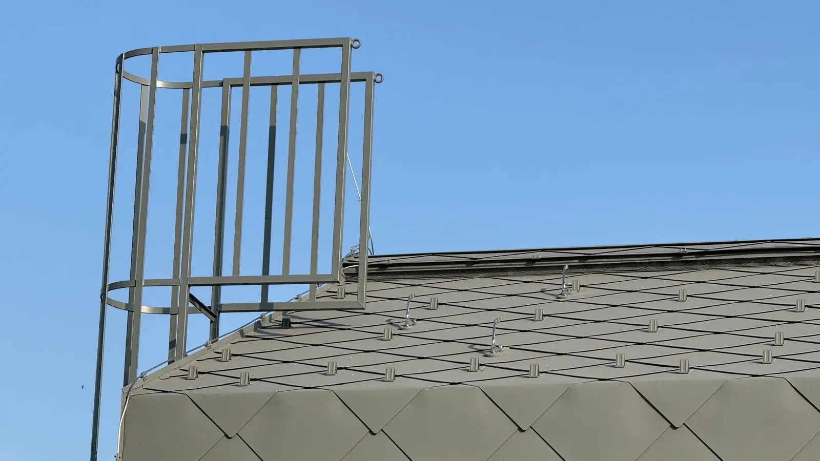 Detailní záběr nároží objektu s PREFA sněhovými háky a bezpečnostními držáky na střeše
