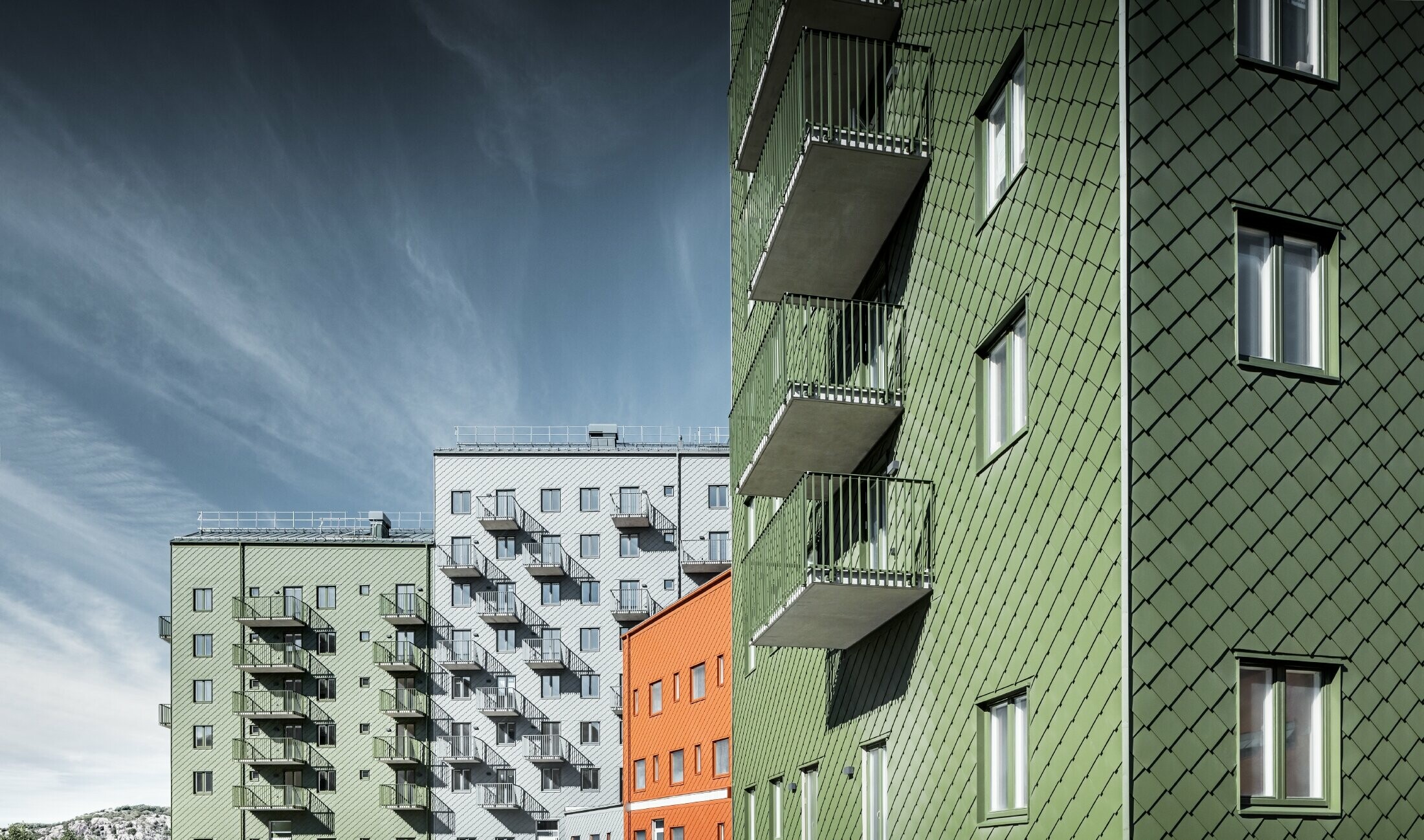 Vysoké panelové domy na švédském sídlišti byly s provětrávanou zavěšenou fasádou z fasádních šablon 29 x 29 od PREFA v různých barvách.