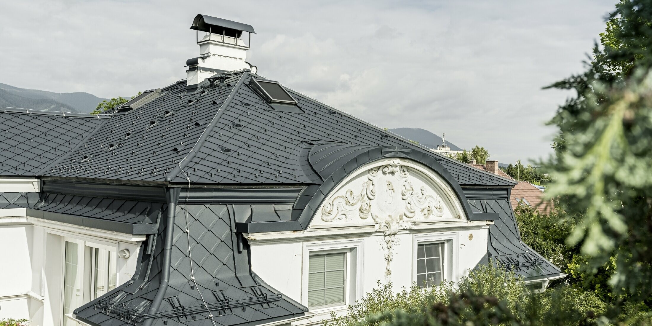 Pohled na střechu historické vily se střechou z falcované šablony 29 × 29 v barvě P.10 antracitové