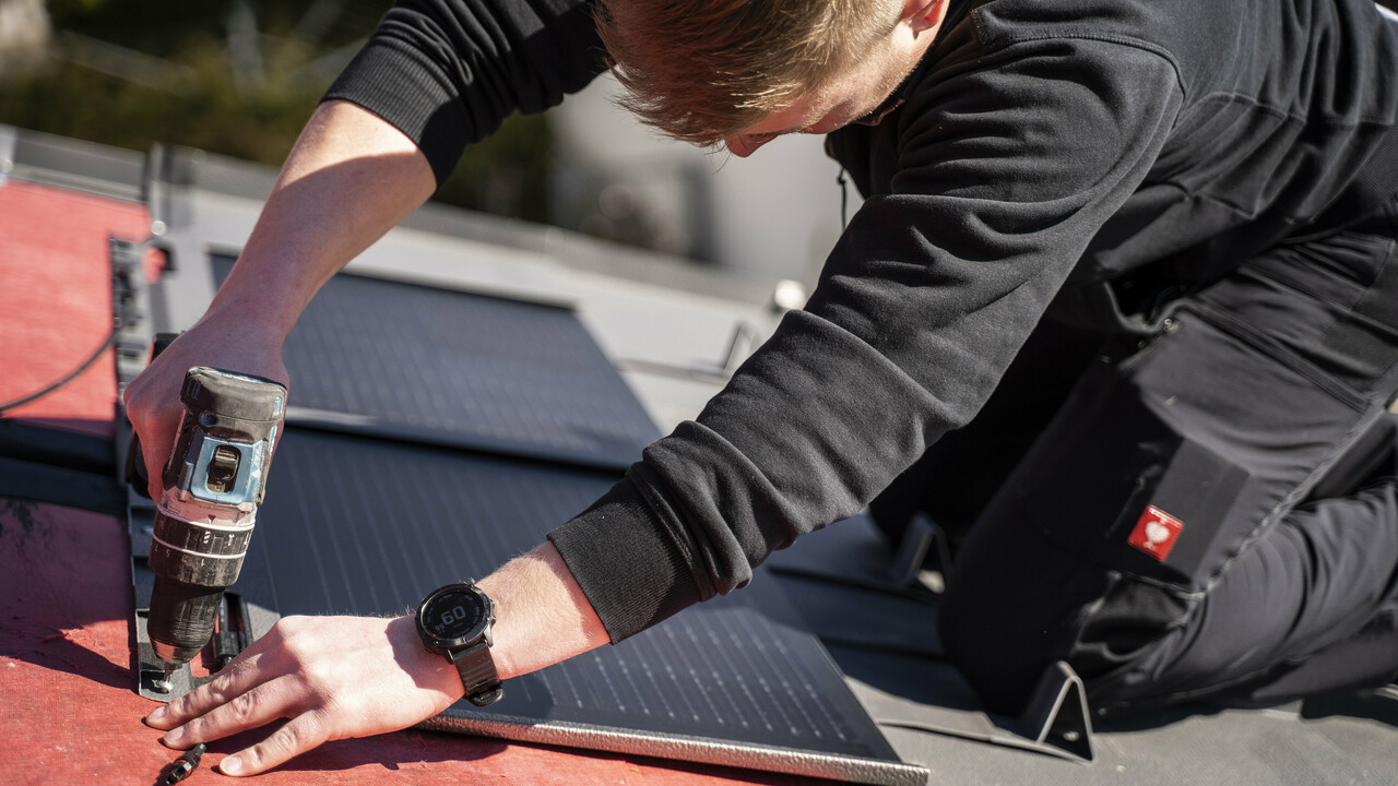 Pracovník PREFA při montáži solárního střešního panelu.