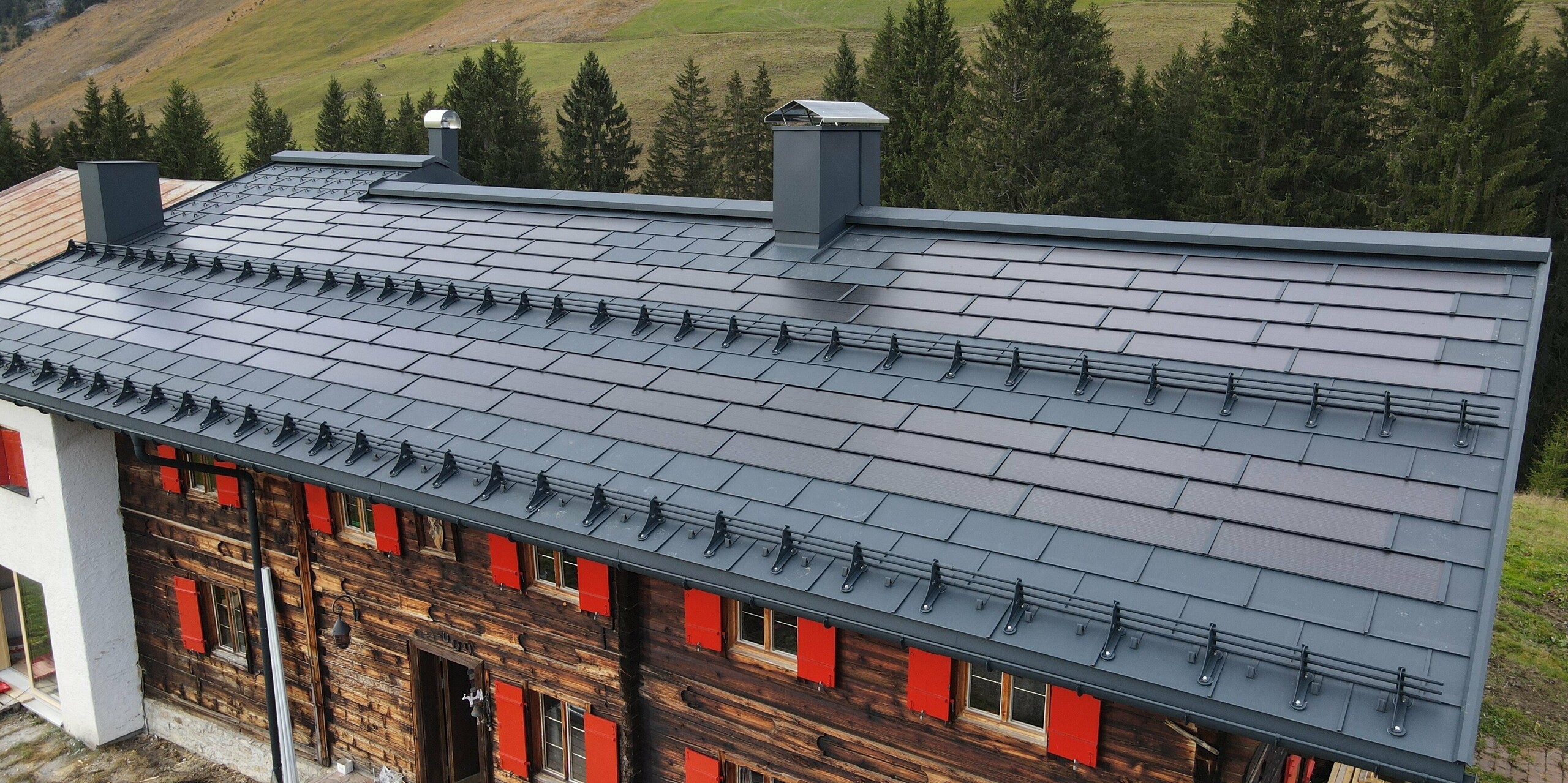 Střešní solární panel a protisněhové prvky na střeše rozlehlého domu