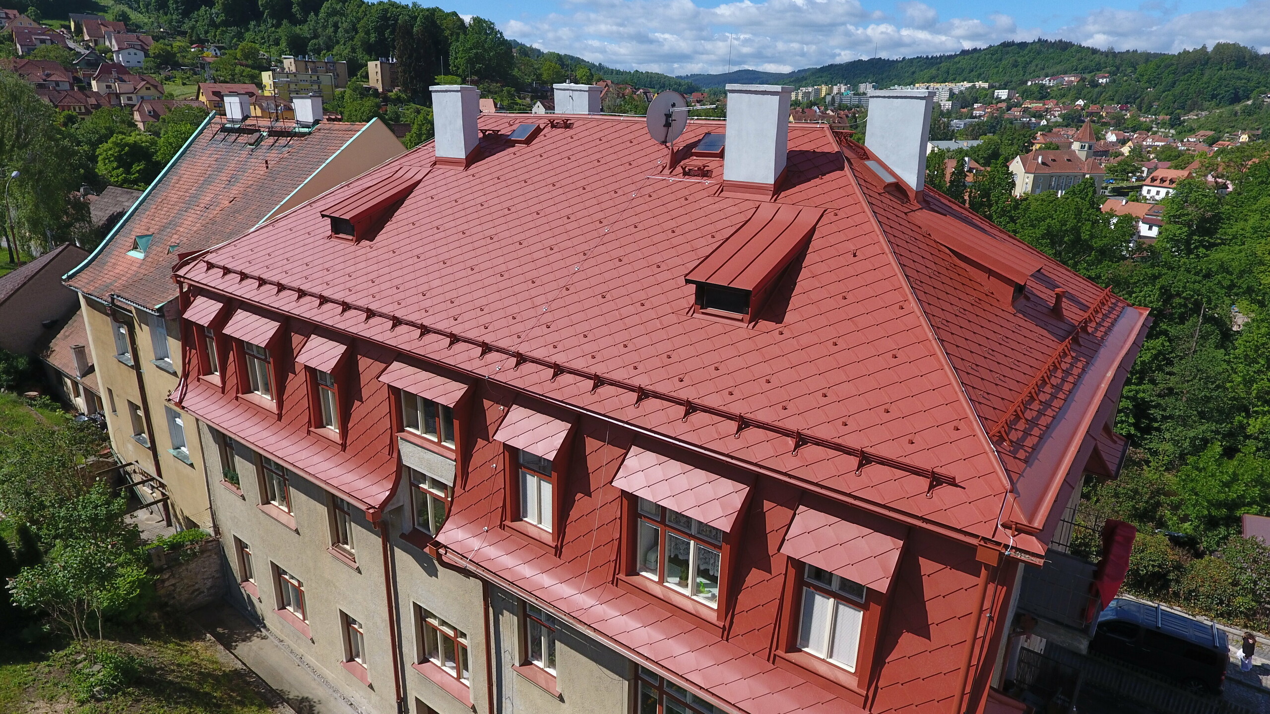 Střecha pokrytá falcovanou šablonou 29 × 29 a svitkovým plechem PREFALZ v barvě P.10 cihlově červené